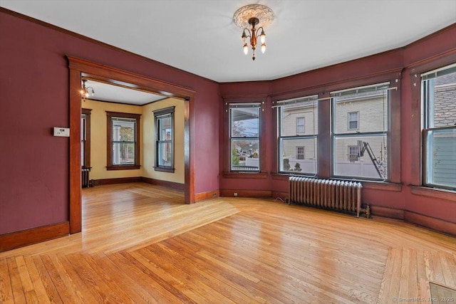 289 Gulf St, Milford, CT 06460 - empty room with light wood-type flooring, ornamental molding, baseboards, an inviting chandelier, and radiator