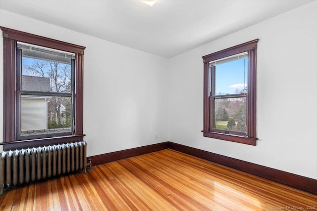 289 Gulf St, Milford, CT 06460 - empty room featuring baseboards, light wood finished floors, radiator, and plenty of natural light
