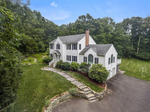 10 Applegate Ln, Monroe, CT 06468 - colonial-style house featuring an attached garage, driveway, a chimney, a front lawn, and a forest view
