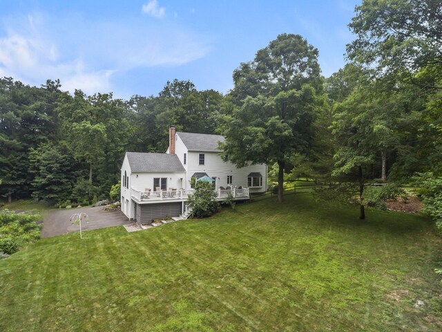 10 Applegate Ln, Monroe, CT 06468 - exterior space with a lawn, a wooden deck, a chimney, a view of trees, and asphalt driveway