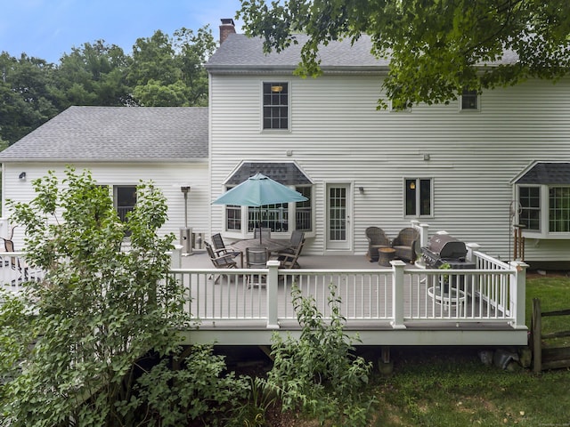 10 Applegate Ln, Monroe, CT 06468 - back of house with a chimney, outdoor dining area, a wooden deck, and roof with shingles