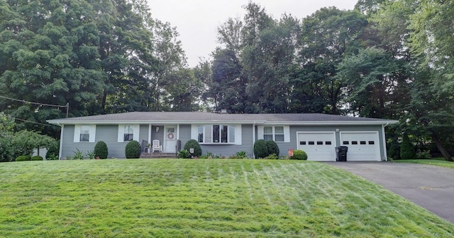 single story home featuring a garage, aphalt driveway, and a front yard