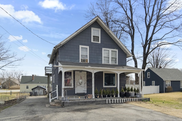 view of front of house with a porch, cooling unit, fence, and an outdoor structure