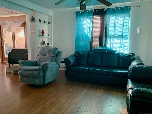 living area featuring ornamental molding, ceiling fan, hardwood / wood-style flooring, and built in shelves