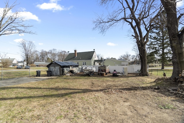 view of yard featuring a storage shed, an outdoor structure, and fence