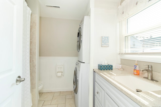 102 Broadway, Milford, CT 06460 - full bath featuring visible vents, tile patterned flooring, wainscoting, stacked washer / dryer, and toilet