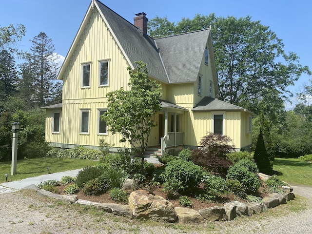 7 Beacon Ln, Norfolk, CT 06058 - view of front of house with roof with shingles, a front yard, a chimney, and board and batten siding
