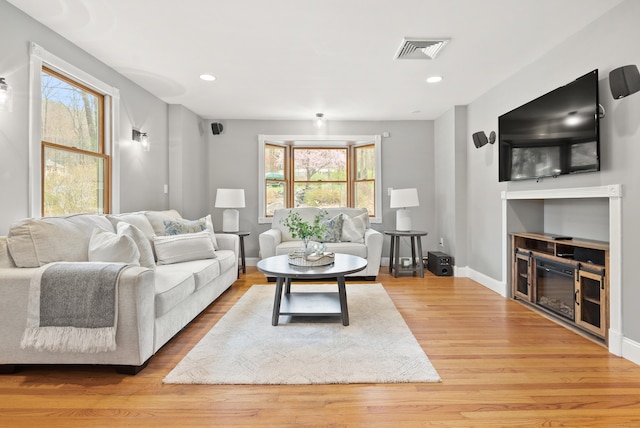 living room featuring baseboards, recessed lighting, wood finished floors, and visible vents