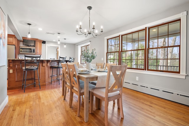 dining area featuring an inviting chandelier, baseboard heating, light wood finished floors, recessed lighting, and visible vents