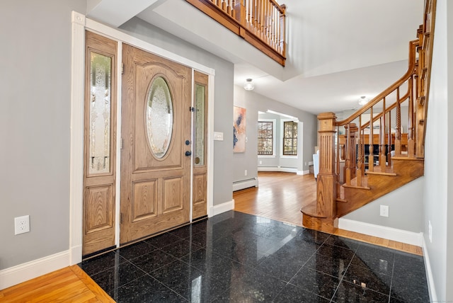 entrance foyer featuring stairway, baseboards, baseboard heating, and granite finish floor