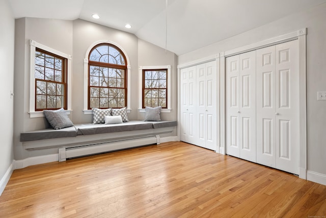 living area with recessed lighting, baseboards, vaulted ceiling, light wood-type flooring, and a baseboard heating unit