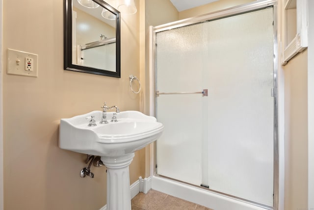 bathroom with tile patterned floors, baseboards, and a shower stall