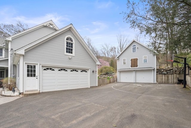 view of side of property featuring a detached garage and fence