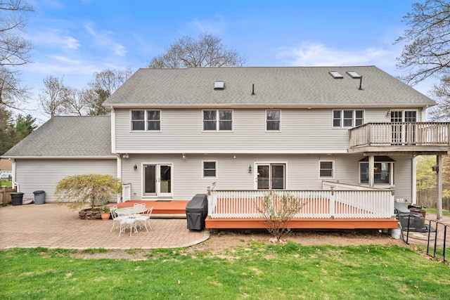 back of property with a patio, a lawn, and a wooden deck
