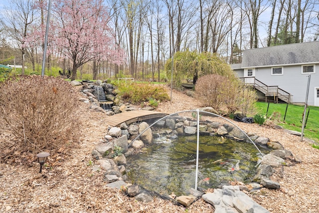 view of yard with a small pond and fence