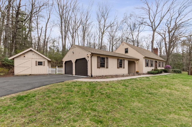 17 Fernwood Ln, Somers, CT 06071 - view of front facade with a detached garage, a front yard, a chimney, and fence