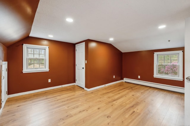 17 Fernwood Ln, Somers, CT 06071 - additional living space with baseboards, baseboard heating, lofted ceiling, and light wood-type flooring