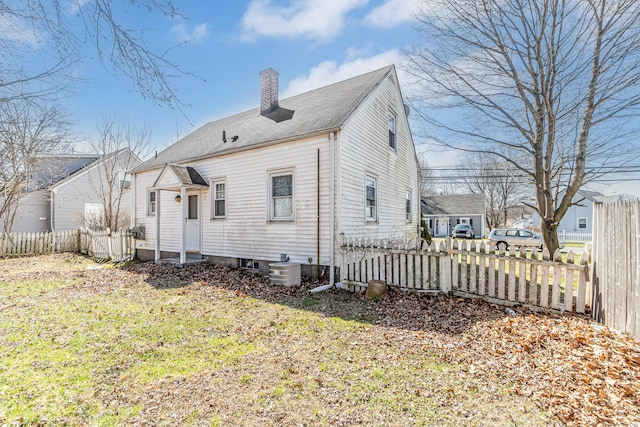 rear view of property featuring central AC, fence private yard, and a chimney