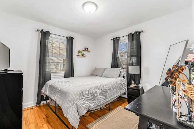 bedroom featuring light wood finished floors and baseboards