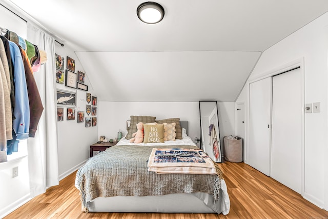 bedroom with vaulted ceiling and wood finished floors