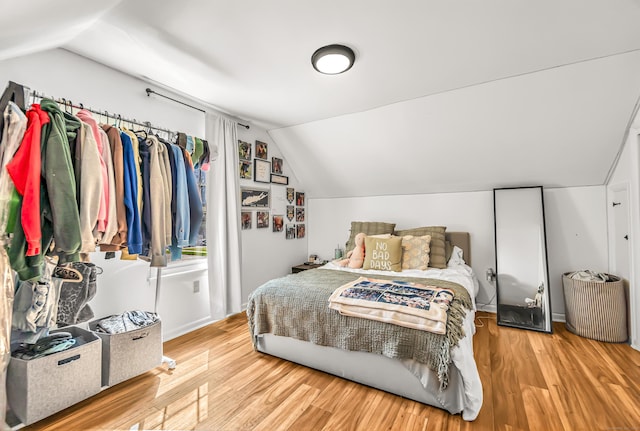 bedroom featuring wood finished floors and vaulted ceiling