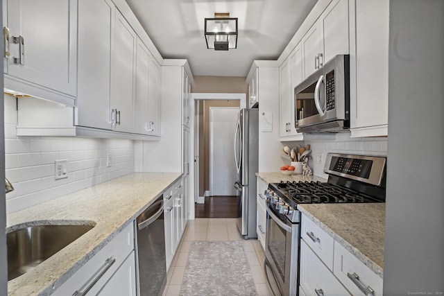 2625 Park Ave Phj, Phj, Bridgeport, CT 06604 - kitchen featuring light tile patterned floors, decorative backsplash, white cabinets, and appliances with stainless steel finishes