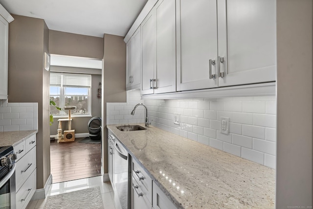 2625 Park Ave Phj, Phj, Bridgeport, CT 06604 - kitchen featuring light stone counters, a sink, baseboards, tasteful backsplash, and appliances with stainless steel finishes