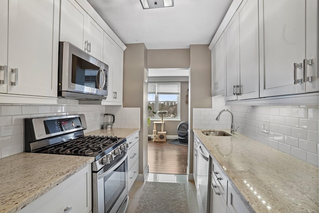 2625 Park Ave Phj, Phj, Bridgeport, CT 06604 - kitchen with white cabinets, backsplash, a sink, light stone countertops, and appliances with stainless steel finishes