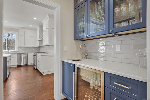 52 Morningside Dr, Greenwich, CT 06830 - indoor wet bar featuring appliances with stainless steel finishes, wine cooler, decorative backsplash, dark wood-style floors, and crown molding
