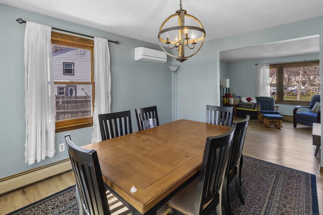87 Summit St, Newington, CT 06111 - dining space with a wall mounted AC, a notable chandelier, a baseboard radiator, and wood finished floors