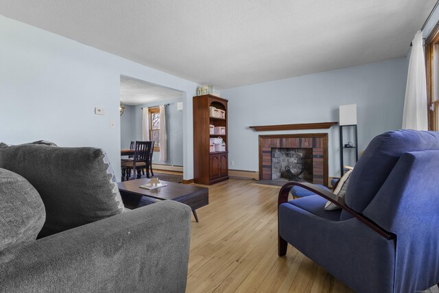 87 Summit St, Newington, CT 06111 - living area with baseboard heating, light wood-type flooring, and a brick fireplace