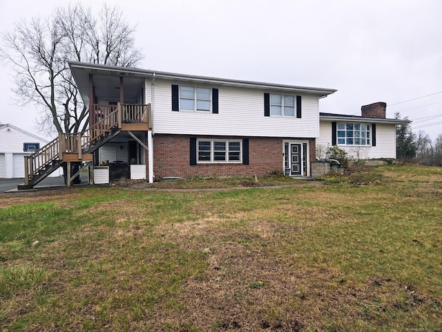 257 Main St, East Windsor, CT 06088 - tri-level home featuring a front lawn, a chimney, stairs, and brick siding