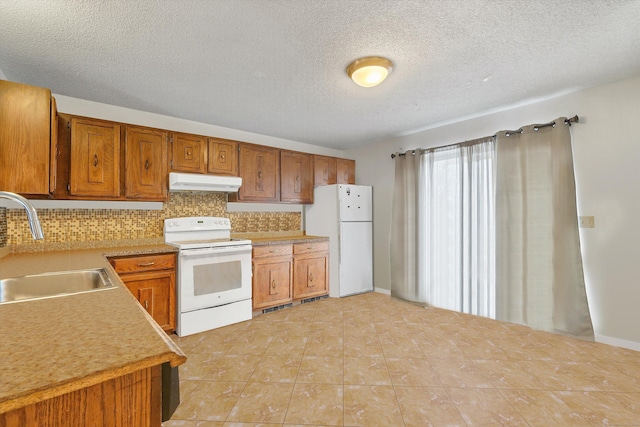 121-123 Sumac St, Waterbury, CT 06704 - kitchen with backsplash, a sink, light countertops, under cabinet range hood, and white appliances