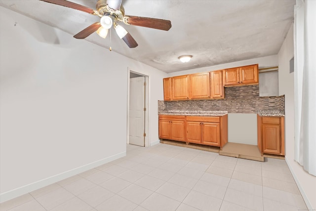 121-123 Sumac St, Waterbury, CT 06704 - kitchen with brown cabinetry, decorative backsplash, light tile patterned flooring, baseboards, and a ceiling fan