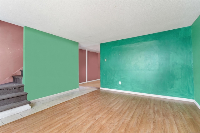 121-123 Sumac St, Waterbury, CT 06704 - unfurnished living room featuring baseboards, a textured ceiling, stairs, and wood finished floors