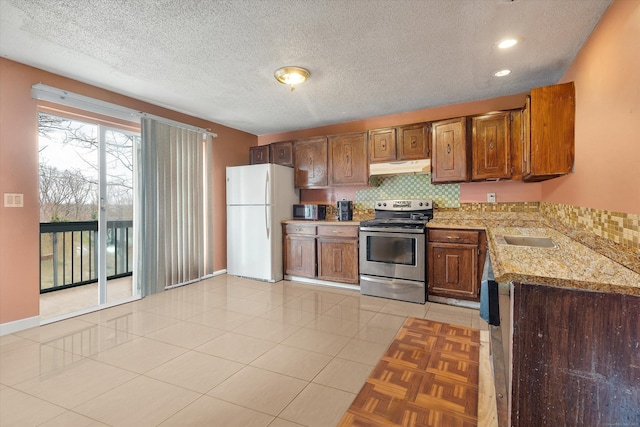 121-123 Sumac St, Waterbury, CT 06704 - kitchen with tasteful backsplash, freestanding refrigerator, under cabinet range hood, and stainless steel range with electric cooktop