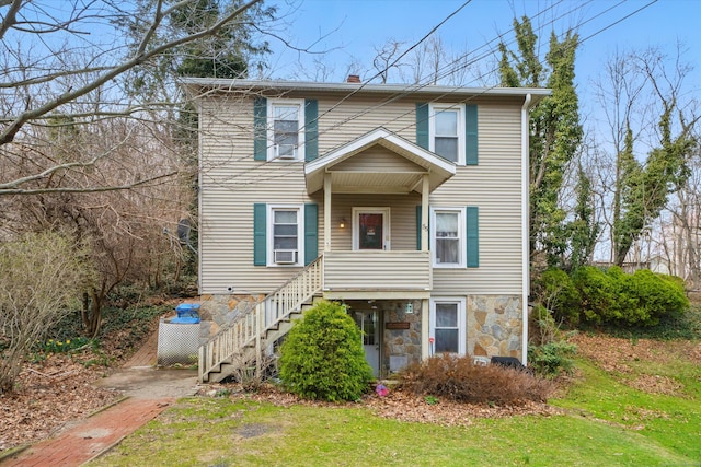 view of front of property featuring a chimney, stone siding, stairway, cooling unit, and a front lawn