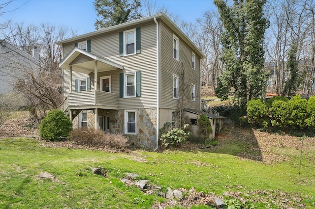 view of front of property featuring a front lawn and stone siding