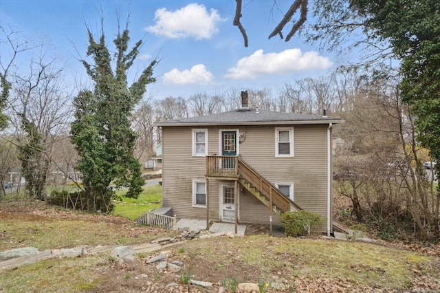 rear view of house with a chimney and stairway