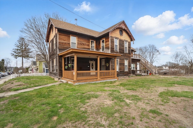 rear view of house with a lawn and a shingled roof