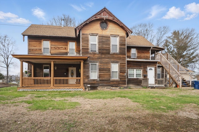 view of front of house with a porch, a front lawn, stairs, and roof with shingles