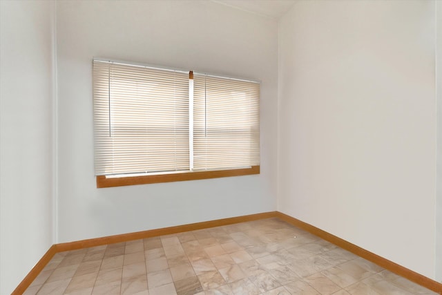 unfurnished room with baseboards