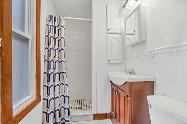 full bathroom featuring wainscoting, a shower stall, toilet, and vanity