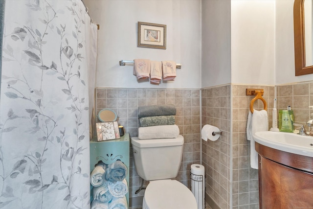full bath with tile walls, toilet, a shower with curtain, and vanity