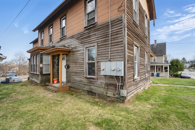 view of side of home with a yard