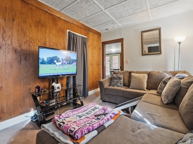 carpeted living area with wooden walls and french doors