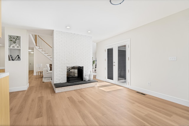 8 Goodsell Rd, Hamden, CT 06473 - unfurnished living room with light wood finished floors, baseboards, a brick fireplace, recessed lighting, and stairway
