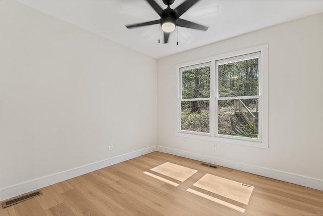 unfurnished room featuring baseboards, visible vents, and light wood-style floors