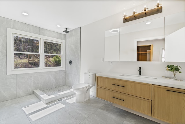 bathroom with recessed lighting, a tile shower, toilet, vanity, and visible vents