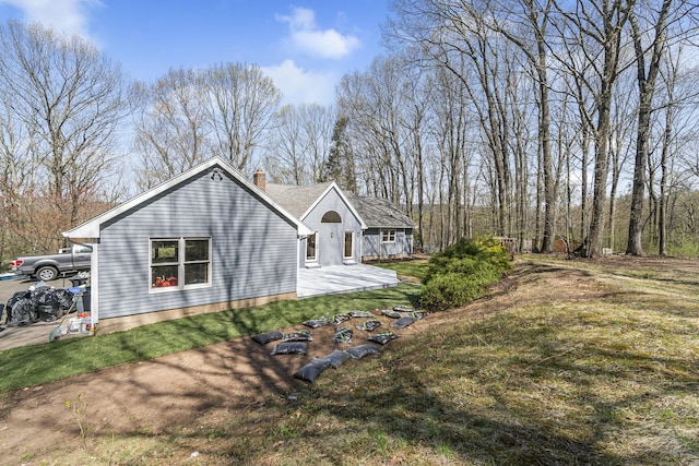 view of property exterior with a lawn and a chimney